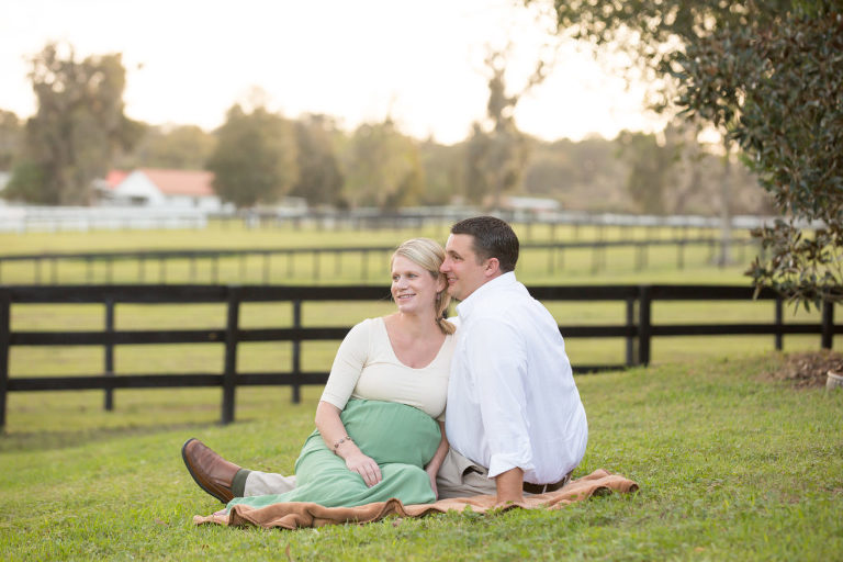 Maternity couple sitting in a field