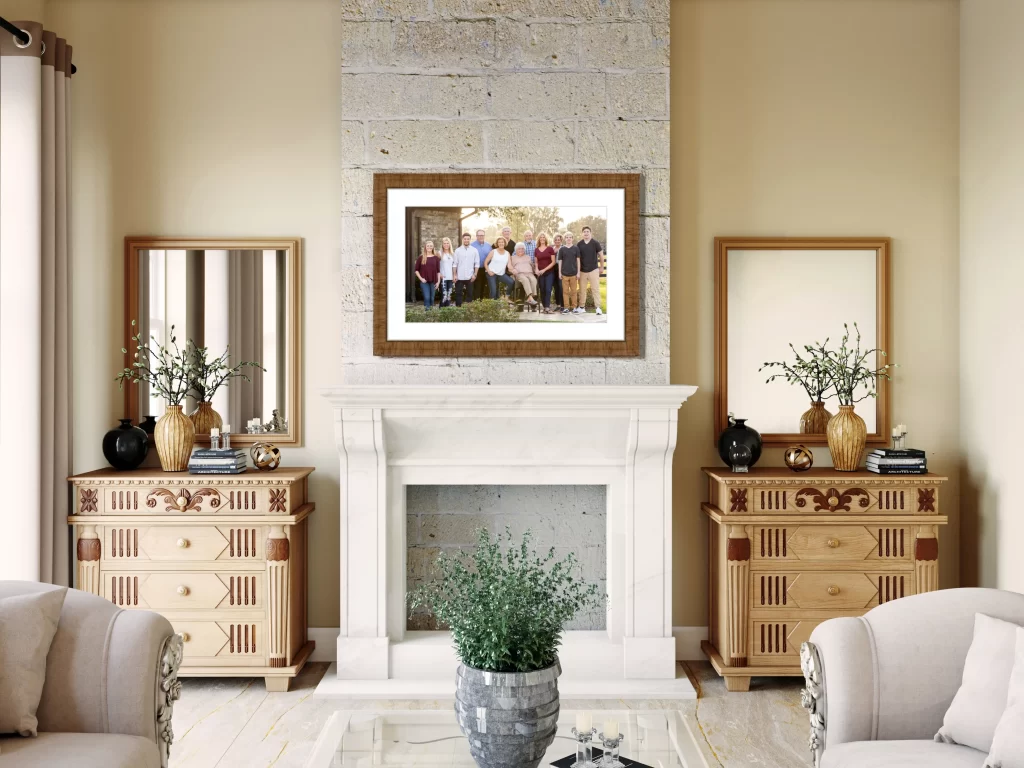 Framed extended family portrait above a traditional stone fireplace in a bright, elegant living room