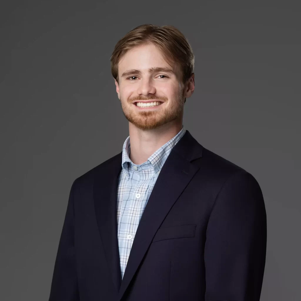 Professional headshot in business attire on a dark background, photographed in Ocala.