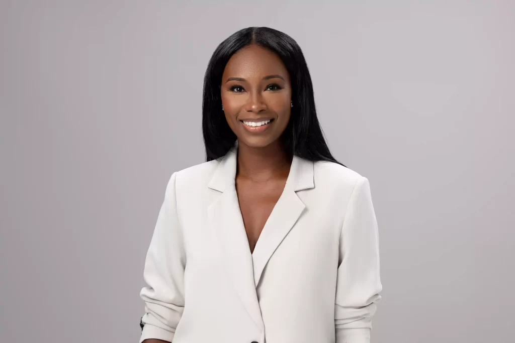 Professional headshot in cream blazer on a grey background, photographed in Ocala.