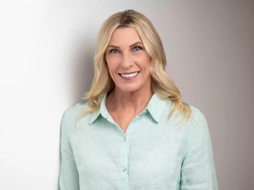 Professional headshot in green shirt on a white background, photographed in Ocala.