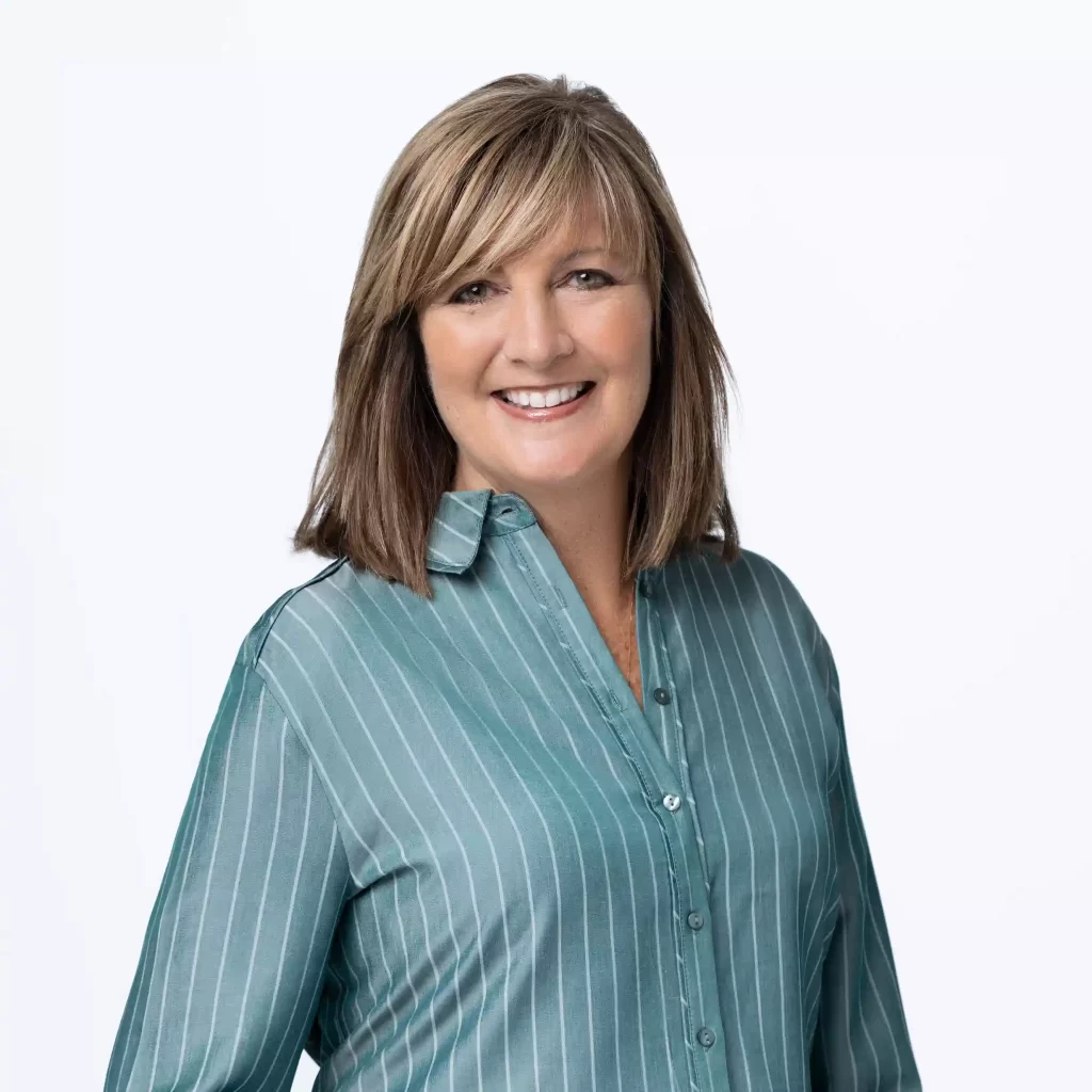 Professional headshot in striped blouse on a white background, photographed in Ocala.