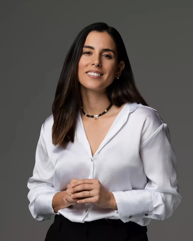Professional headshot of woman in white blouse on a grey backdrop, photographed in Ocala.